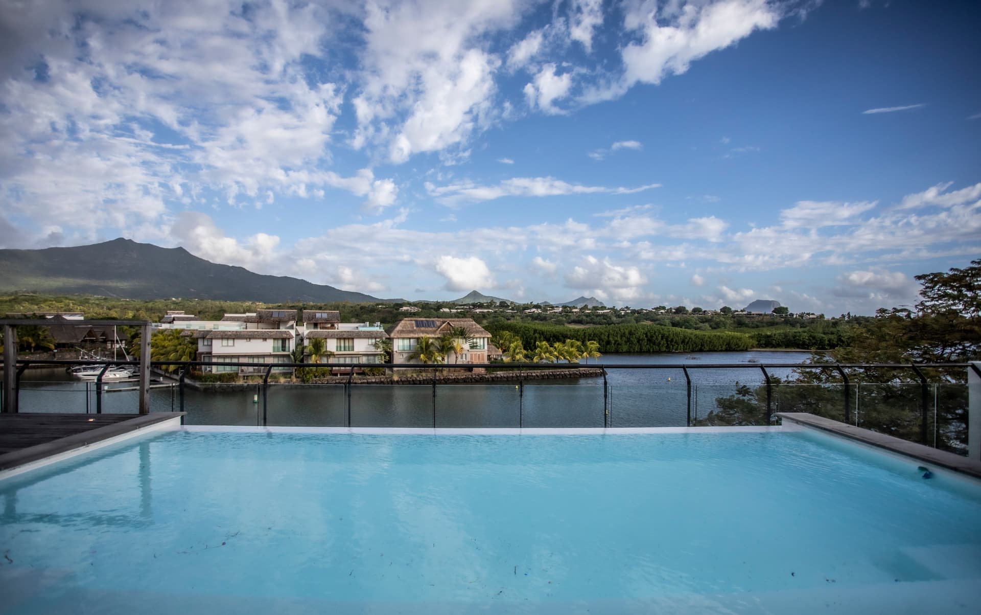 Vue panoramique sur la rivière et les collines depuis la terrasse.  

Piscine avec eau claire offrant un espace de détente.  

Terrasse bordée de verre pour une vue dégagée sur l'environnement.  

Mobilier extérieur moderne permettant de profiter de l'espace.  

Ciel dégagé créant une ambiance lumineuse et ouverte.
