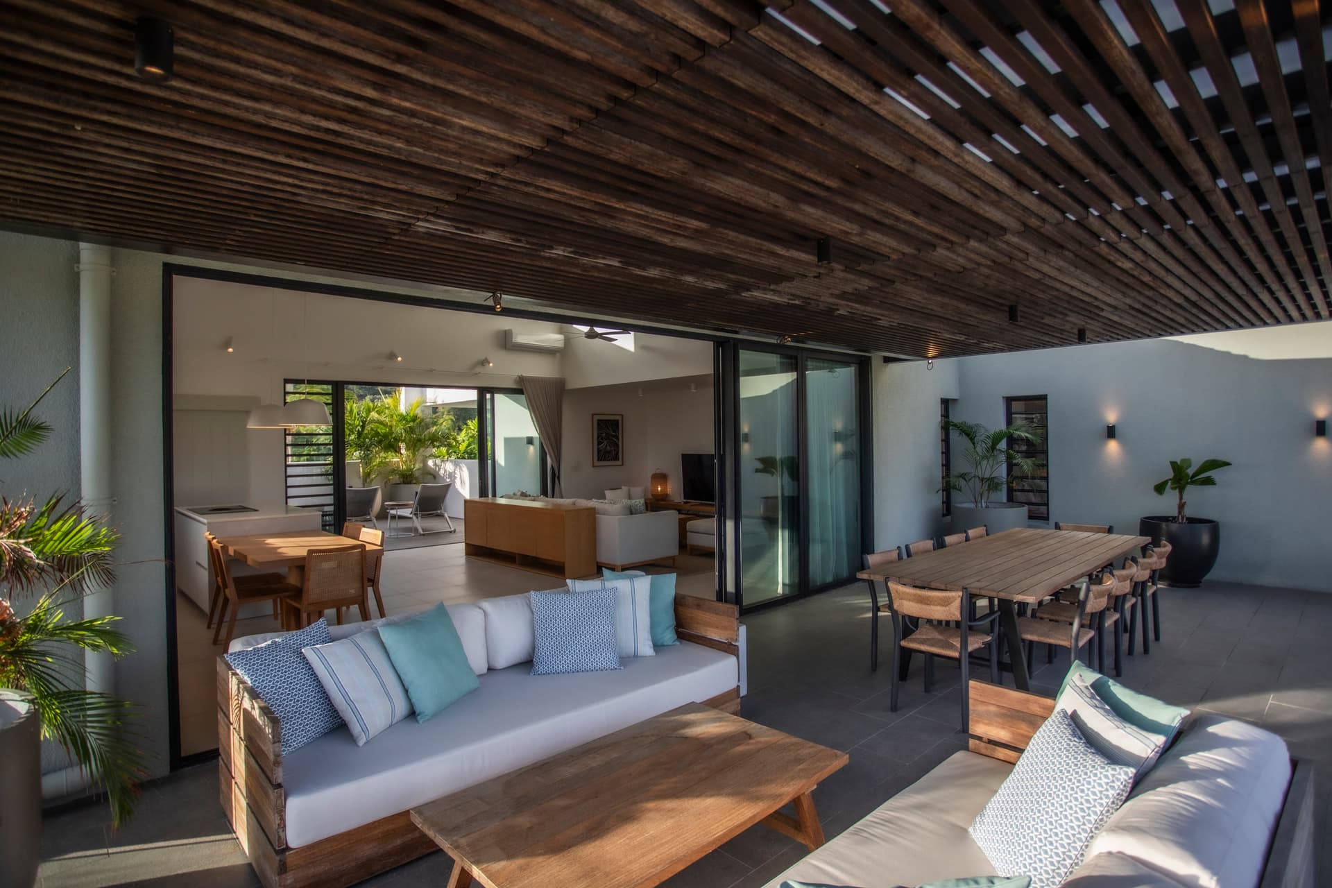 Espace de vie intérieur avec baies vitrées pour une lumière naturelle abondante. 

Plafond en bois ajoutant une touche d'élégance à l'aménagement. 

Mobilier moderne en bois favorisant le confort et la convivialité. 

Zone de repas intégrée avec une grande table pour des occasions partagées. 

Accès direct à la terrasse pour profiter de l'extérieur
