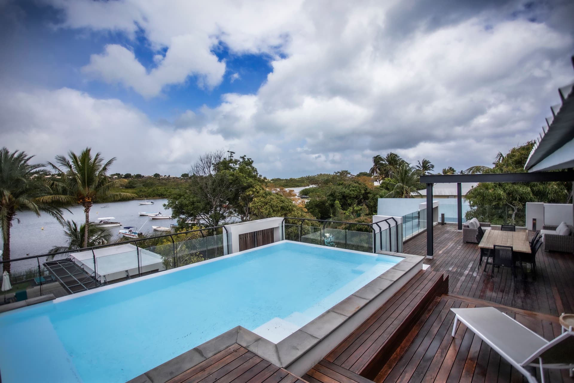Teintes bleues et surfaces lisses autour de la piscine privée.  
Terrasse spacieuse offrant une vue sur le paysage environnant.  
Mobilier en bois disposé pour des moments de détente en extérieur.  
Espace idéal pour profiter du climat tropical de l'île.  
Accès direct depuis le penthouse pour une utilisation pratique.