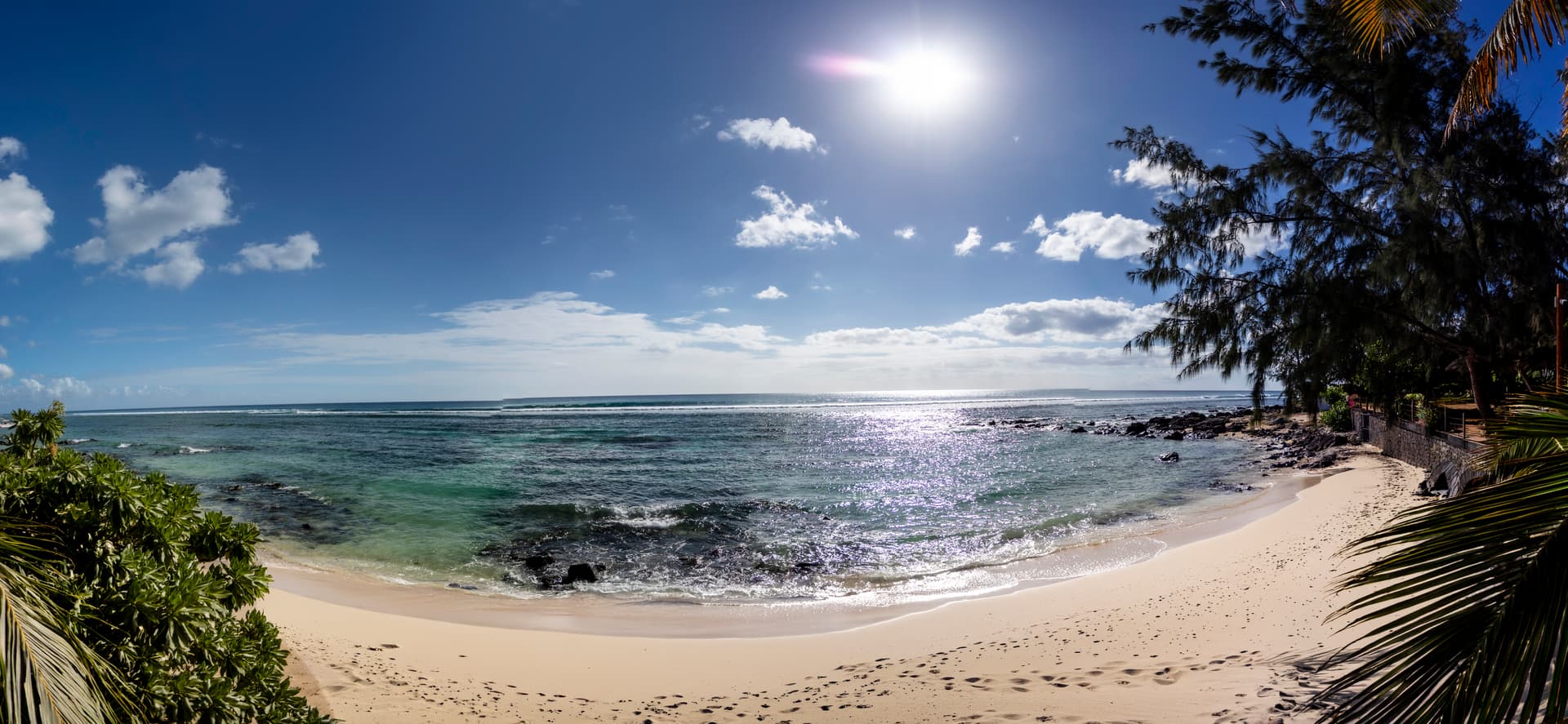 Vue dégagée sur la plage et l'océan, offrant une atmosphère sereine.  
Lumière naturelle illuminant la pièce grâce aux grandes fenêtres.  
Accès direct au sable fin depuis l'espace extérieur.  
Plantes tropicales ajoutant une touche de verdure à l'environnement côtier.  
Espace propice à la détente tout en admirant le paysage marin.