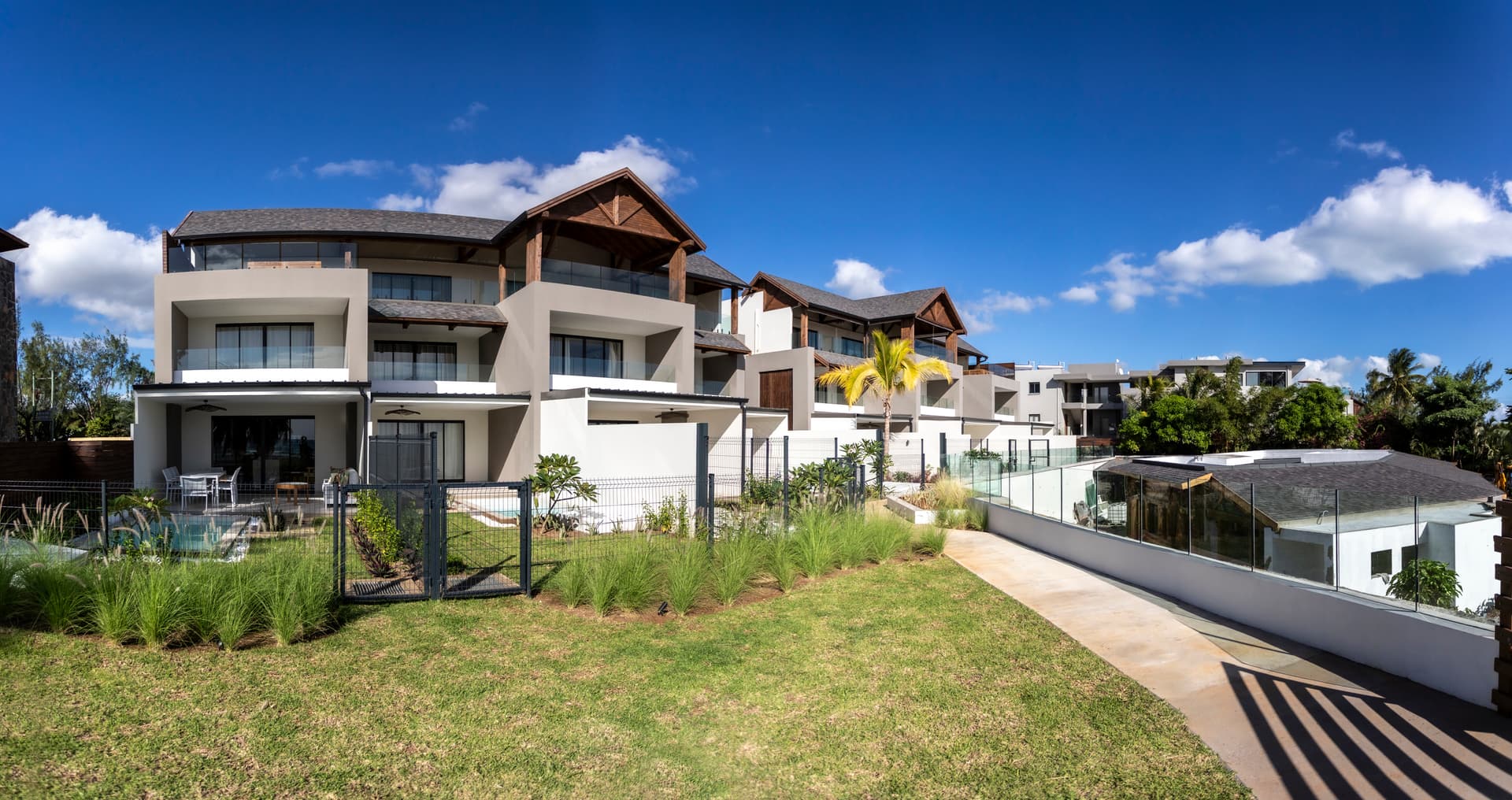 Duplex en bord de mer avec accès direct à la plage.  
Terrasse avec vue sur le jardin et les espaces environnants.  
Jardin paysager offrant un cadre naturel et apaisant.  
Piscine partagée intégrée dans un espace extérieur bien conçu.  
Architecture contemporaine avec lignes épurées et matériaux modernes.