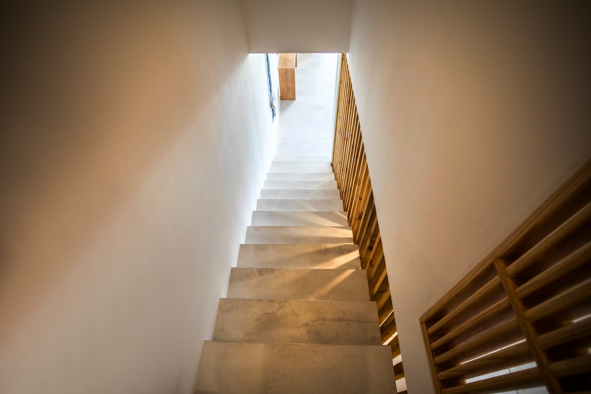 Escalier lumineux menant à l'étage supérieur avec balustrade en bois.  
Lumière naturelle filtrant à travers l'ouverture en haut des marches.  
Matériaux clairs et modernes créant un environnement épuré.  
Accès facilité aux espaces de vie supérieurs depuis cet escalier.  
Design simple et fonctionnel offrant une circulation fluide.