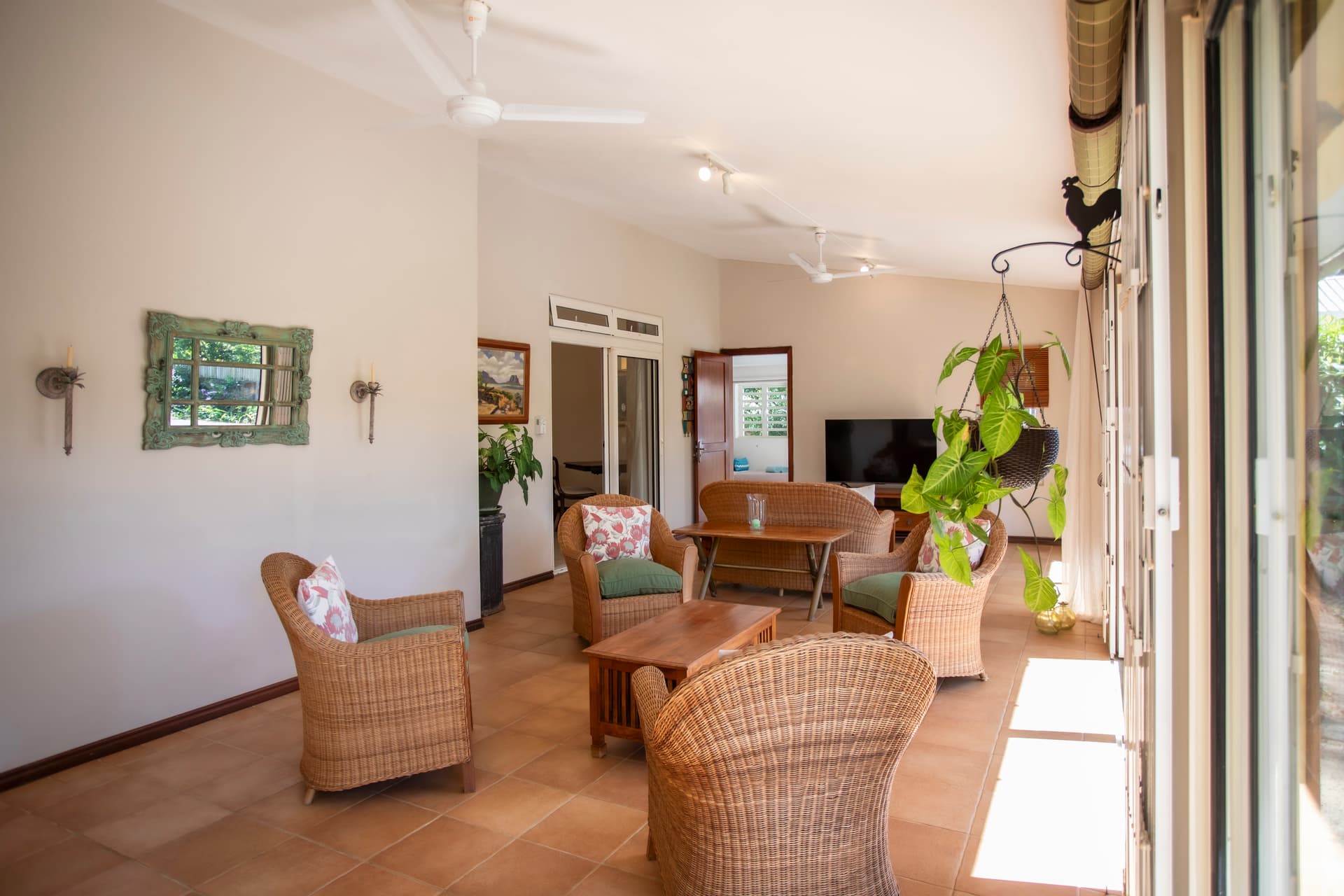 Espace ouvert avec ventilateurs au plafond et lumière naturelle. Accès direct au jardin.